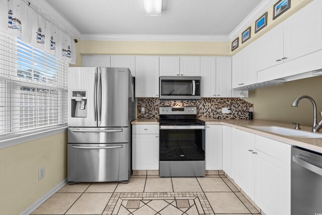 618 3rd Ave S Unit 4D, North Myrtle Beach, SC 29582 - kitchen featuring stainless steel appliances, a sink, light tile patterned floors, light countertops, and backsplash