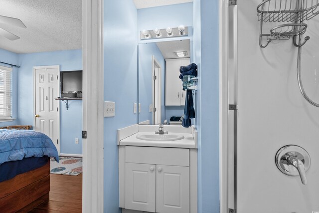 618 3rd Ave S Unit 4D, North Myrtle Beach, SC 29582 - ensuite bathroom featuring a textured ceiling, wood finished floors, vanity, a ceiling fan, and a shower