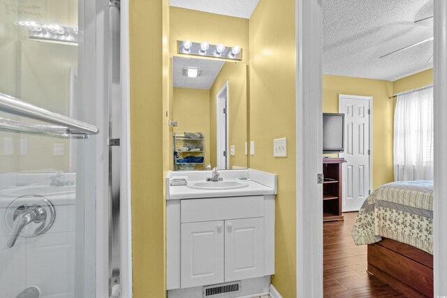 618 3rd Ave S Unit 4D, North Myrtle Beach, SC 29582 - ensuite bathroom with vanity, a textured ceiling, and wood finished floors