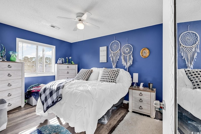 bedroom with ceiling fan, a textured ceiling, and light hardwood / wood-style floors