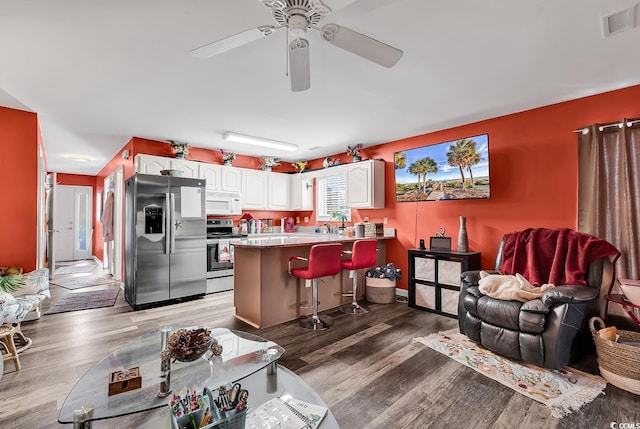living room featuring ceiling fan and hardwood / wood-style floors