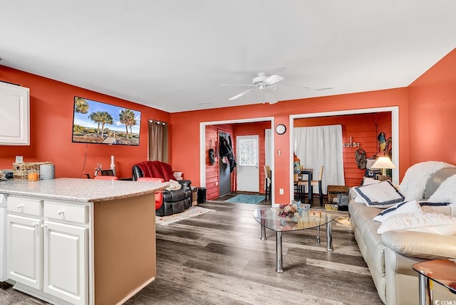 living room featuring dark wood-type flooring and ceiling fan