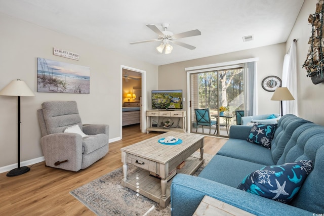 living room with light wood-type flooring and ceiling fan