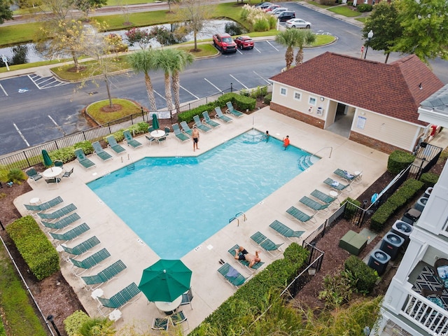 view of pool with a water view and a patio