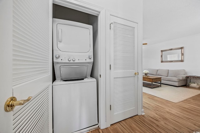 laundry area with stacked washing maching and dryer and light wood-type flooring