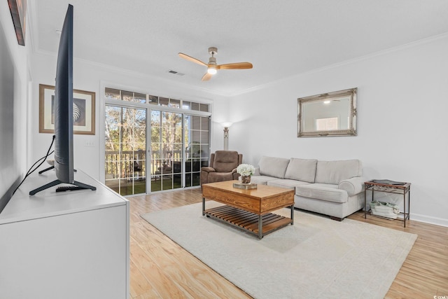 living room featuring ceiling fan, crown molding, and wood-type flooring