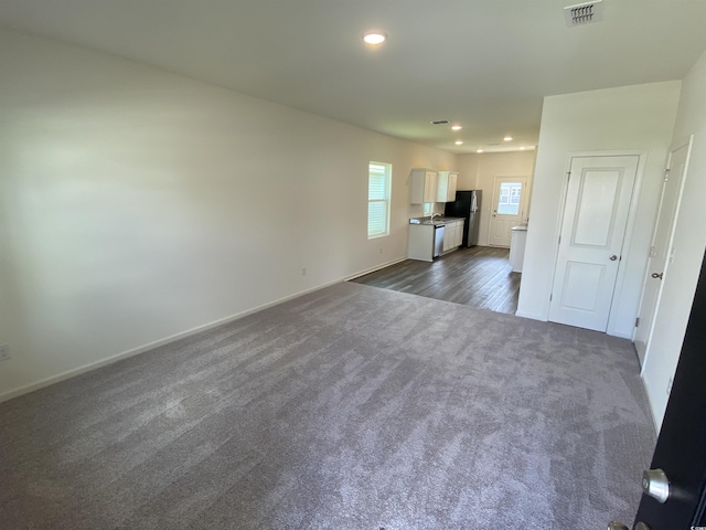 unfurnished living room featuring dark carpet