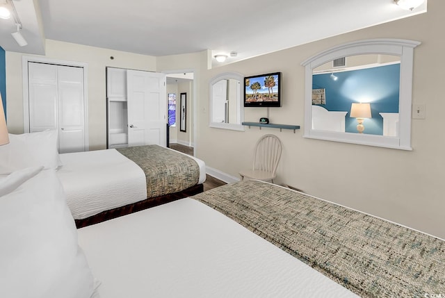 bedroom featuring two closets and hardwood / wood-style floors