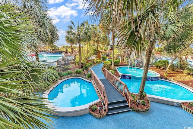 view of swimming pool featuring a jacuzzi and pool water feature