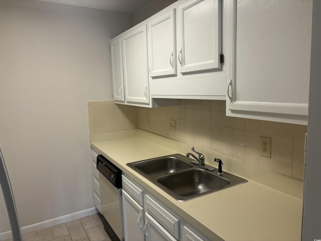 kitchen featuring light countertops, stainless steel dishwasher, a sink, and white cabinetry