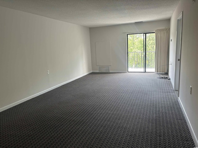 unfurnished room featuring a textured ceiling, dark carpet, visible vents, and baseboards