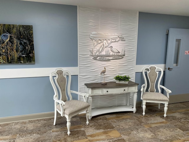 sitting room with stone finish flooring and baseboards