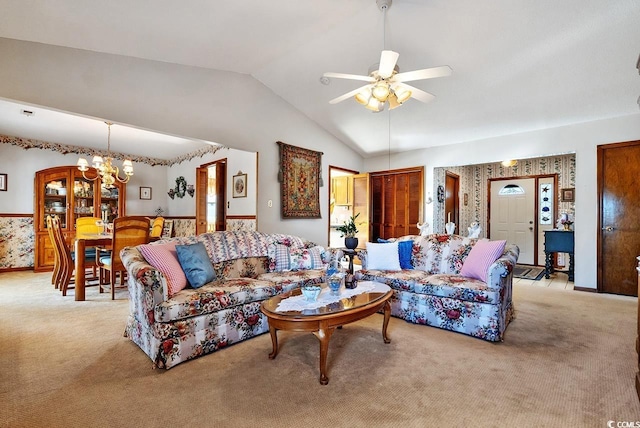 living area featuring light carpet, vaulted ceiling, and ceiling fan with notable chandelier