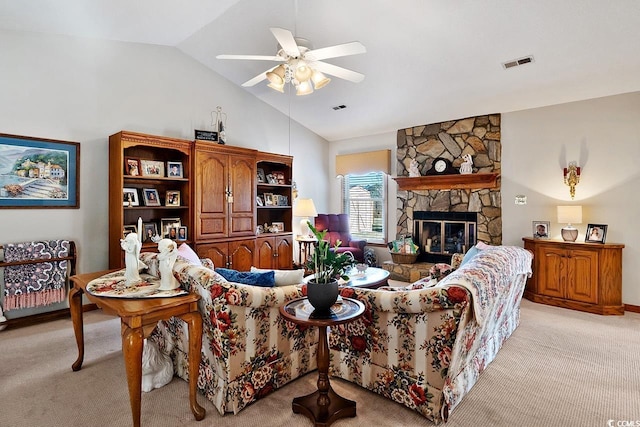 living room featuring light carpet, visible vents, vaulted ceiling, and a stone fireplace