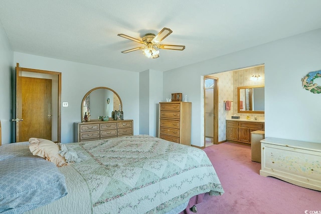 bedroom featuring light colored carpet, ceiling fan, and ensuite bath