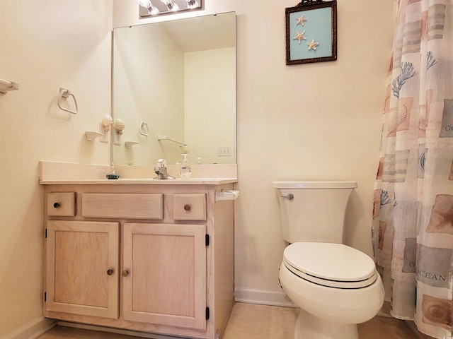 bathroom with toilet, vanity, and curtained shower