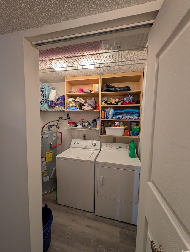 clothes washing area featuring separate washer and dryer, hardwood / wood-style floors, and water heater