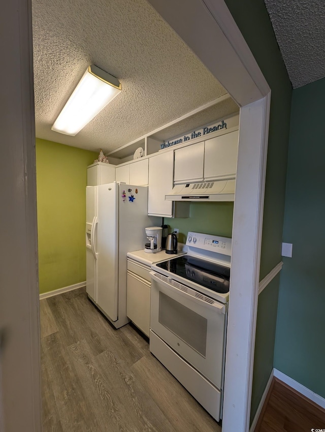 kitchen with light hardwood / wood-style floors, white appliances, white cabinets, and a textured ceiling