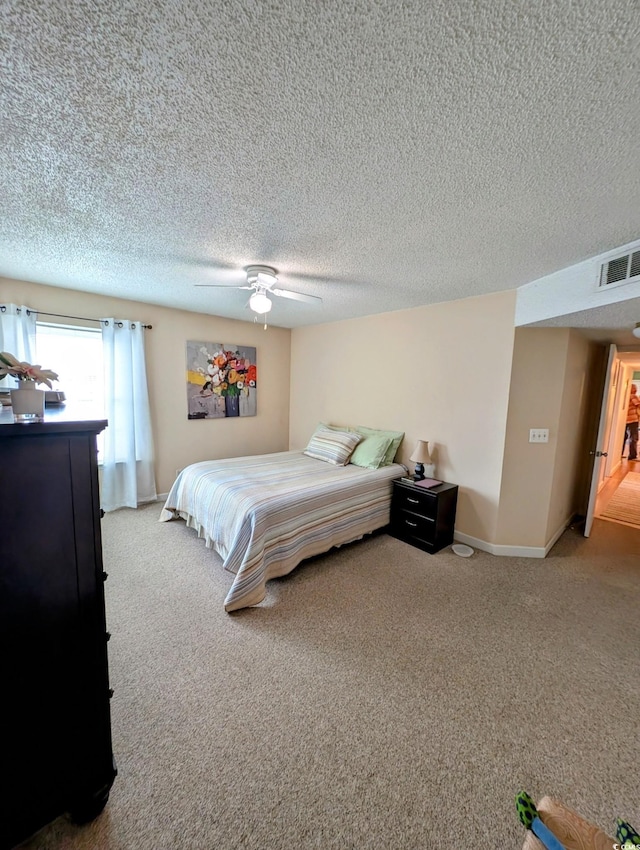 bedroom featuring a textured ceiling, ceiling fan, and carpet