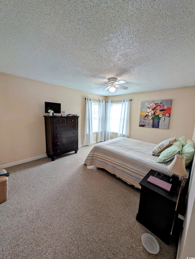 carpeted bedroom with ceiling fan and a textured ceiling