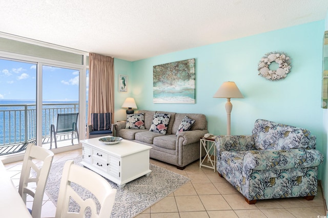 living area featuring a water view, a textured ceiling, and light tile patterned flooring