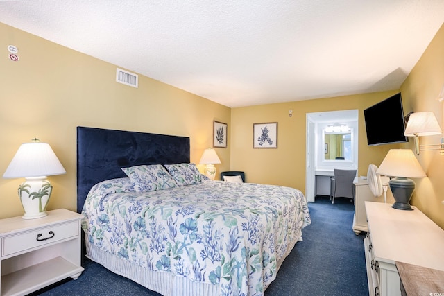 bedroom with connected bathroom, visible vents, dark colored carpet, and a textured ceiling