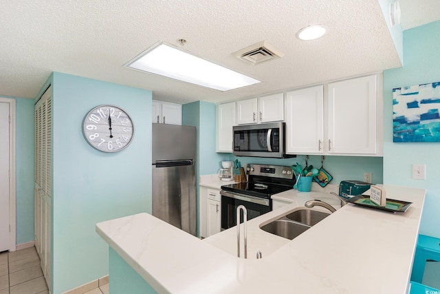 kitchen with light countertops, visible vents, appliances with stainless steel finishes, white cabinetry, and a textured ceiling