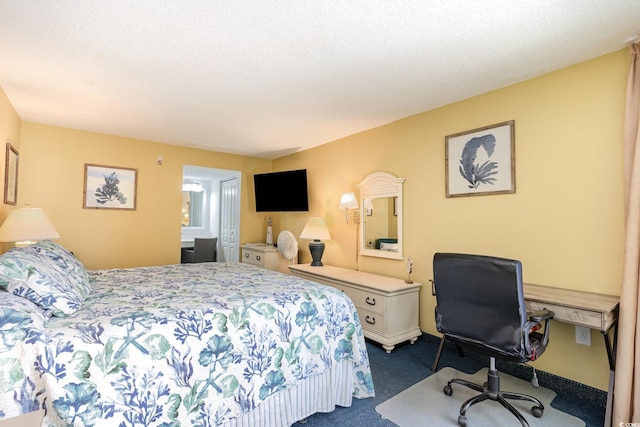 bedroom with a textured ceiling and dark colored carpet