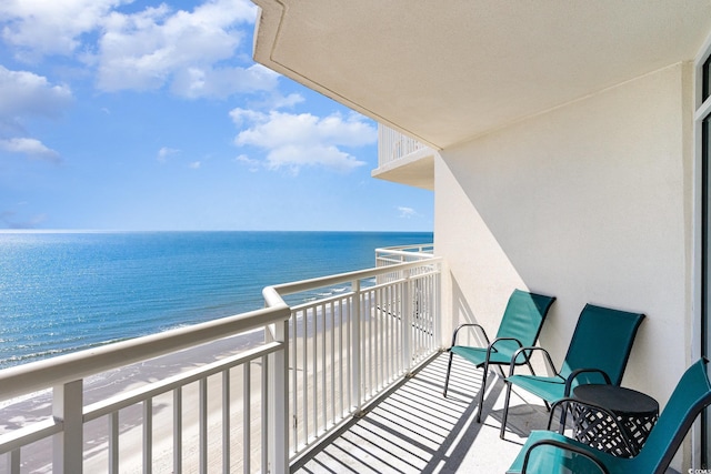 balcony with a water view and a beach view