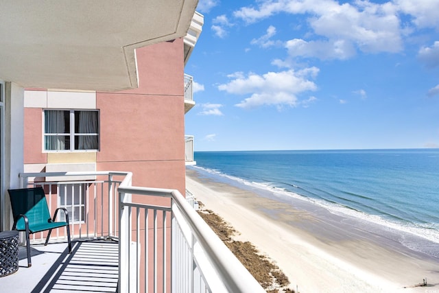 balcony with a water view and a beach view