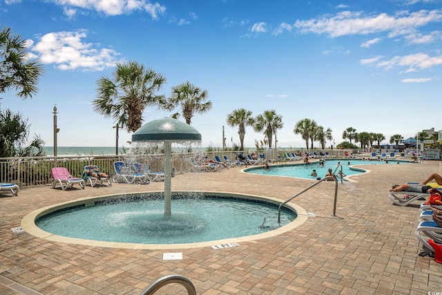 community pool with a patio and fence