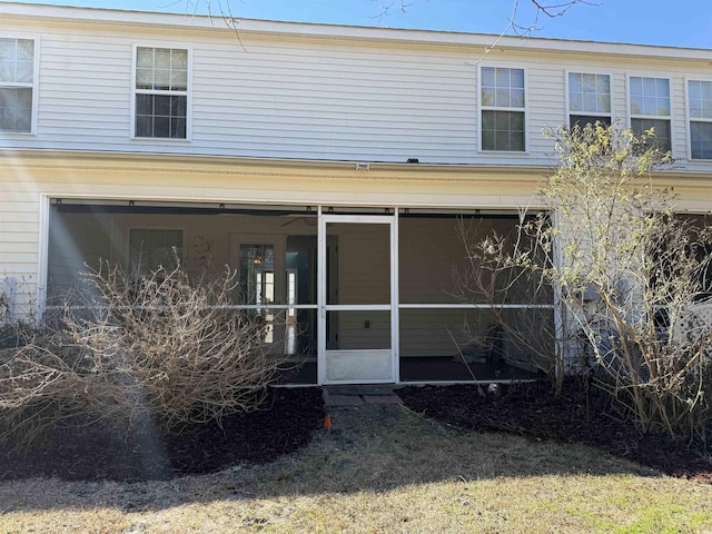 rear view of house featuring a sunroom