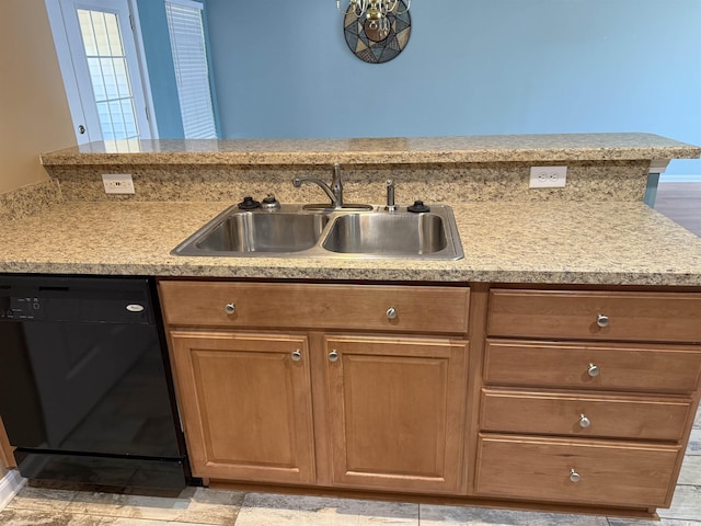 kitchen with black dishwasher, kitchen peninsula, and sink