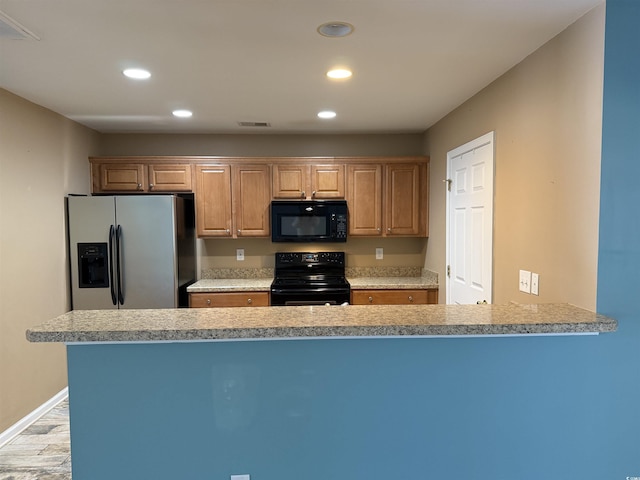 kitchen featuring light wood-type flooring, kitchen peninsula, and black appliances