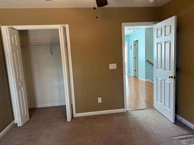 unfurnished bedroom with a closet, carpet, and ceiling fan