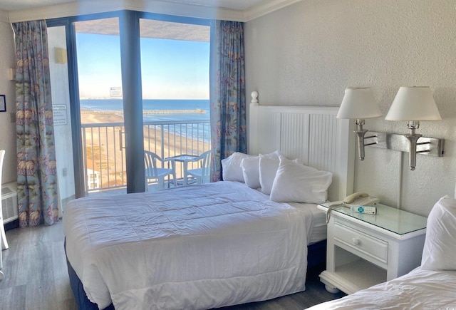 9550 Shore Dr Unit 1226, Myrtle Beach, SC 29572 - bedroom with a water view, a textured wall, multiple windows, and wood finished floors
