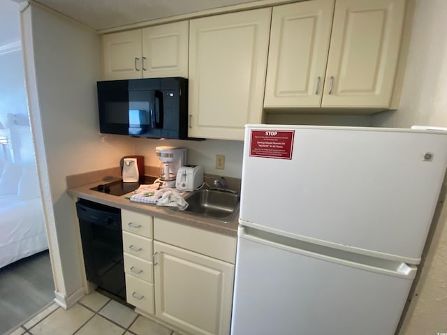 9550 Shore Dr Unit 1226, Myrtle Beach, SC 29572 - kitchen featuring white cabinetry, light tile patterned floors, black appliances, and a sink