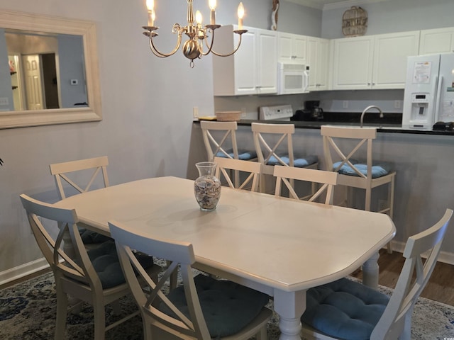 dining space featuring dark hardwood / wood-style floors, sink, and an inviting chandelier