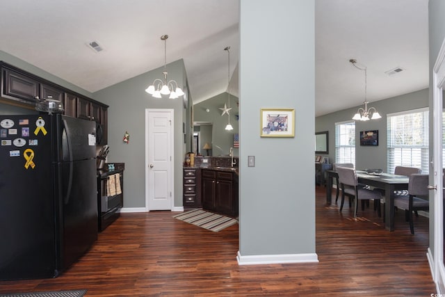 kitchen featuring visible vents, an inviting chandelier, freestanding refrigerator, a sink, and dark brown cabinetry