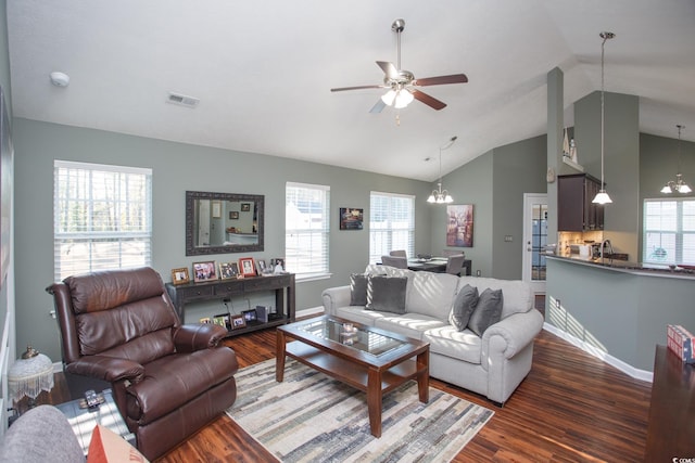 living area featuring visible vents, ceiling fan with notable chandelier, wood finished floors, baseboards, and lofted ceiling