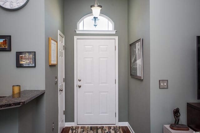 foyer featuring dark wood-style floors and baseboards