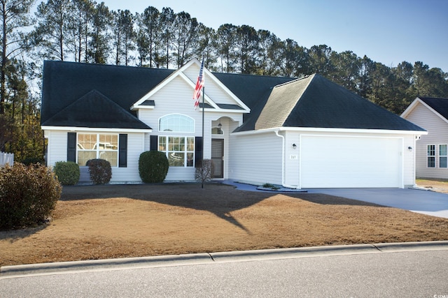 traditional-style house featuring concrete driveway, an attached garage, and a shingled roof