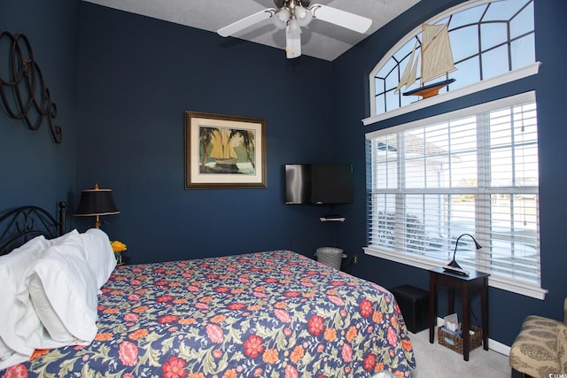 carpeted bedroom with a ceiling fan and baseboards