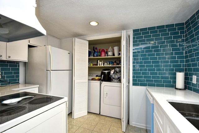 kitchen with white dishwasher, decorative backsplash, and white cabinets