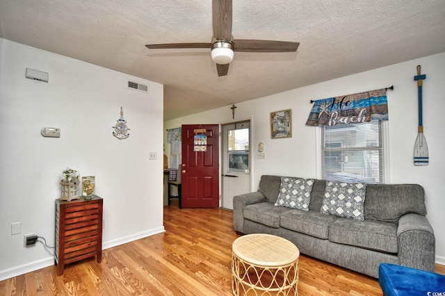 living room with a wealth of natural light, hardwood / wood-style floors, a textured ceiling, and ceiling fan