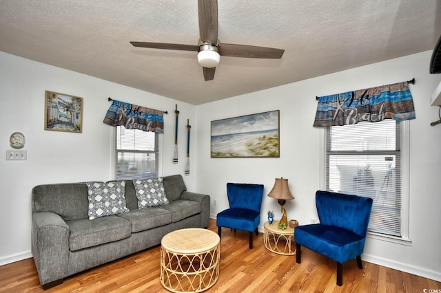 living room with ceiling fan, hardwood / wood-style floors, and a textured ceiling