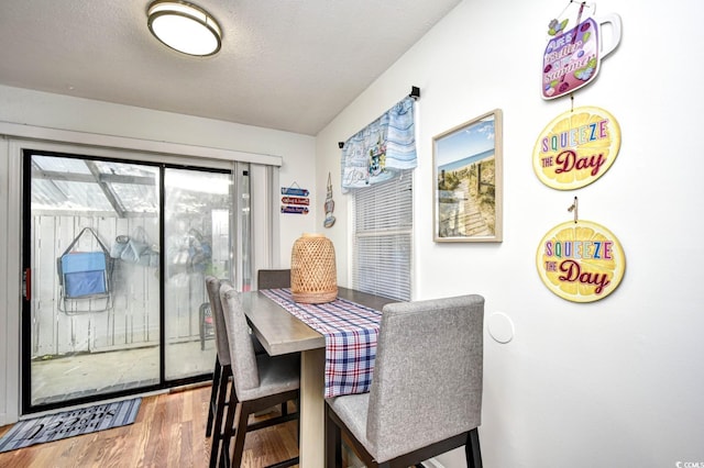 dining area with hardwood / wood-style flooring and a textured ceiling