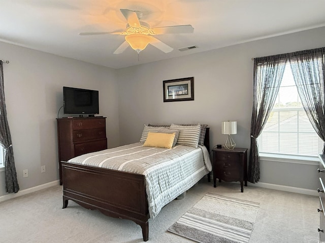 bedroom featuring light carpet, baseboards, visible vents, and a ceiling fan