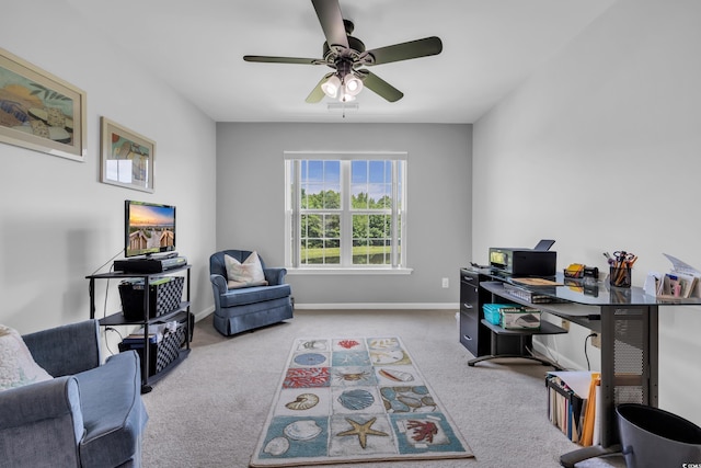 carpeted office space with a ceiling fan and baseboards