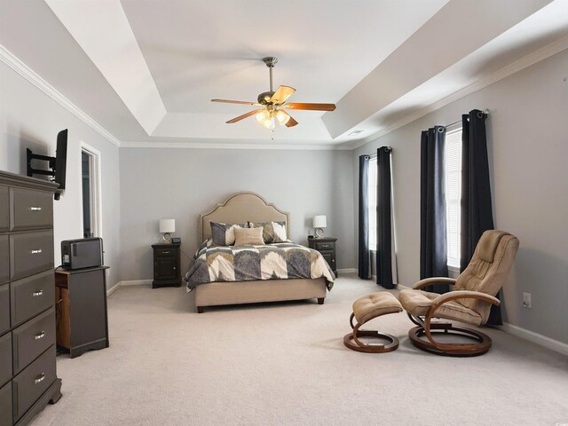 bedroom featuring light carpet, ceiling fan, a tray ceiling, and multiple windows